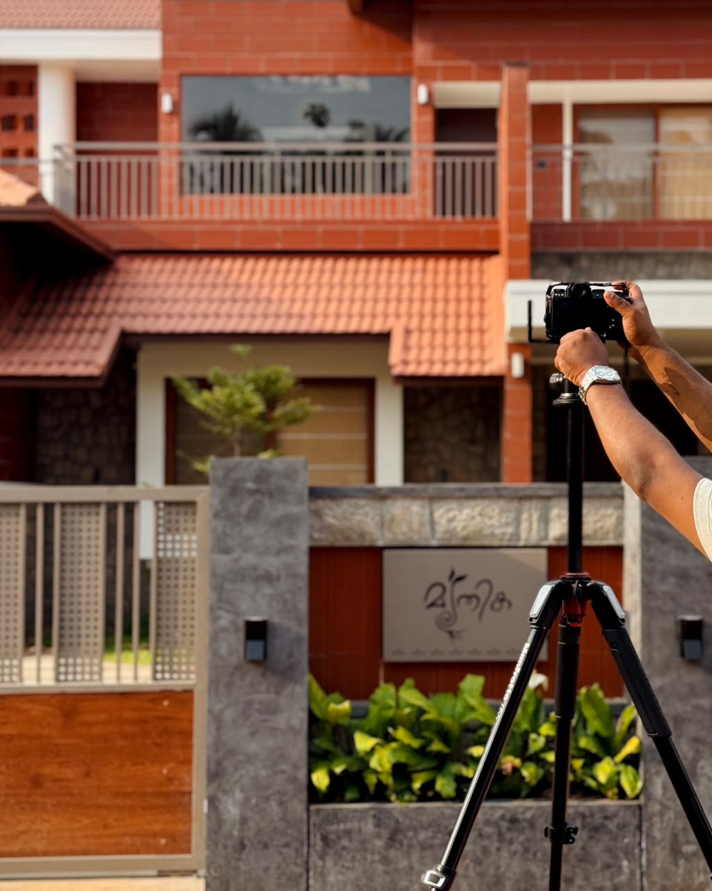 Photographer setting up camera on tripod inside a stone-walled home